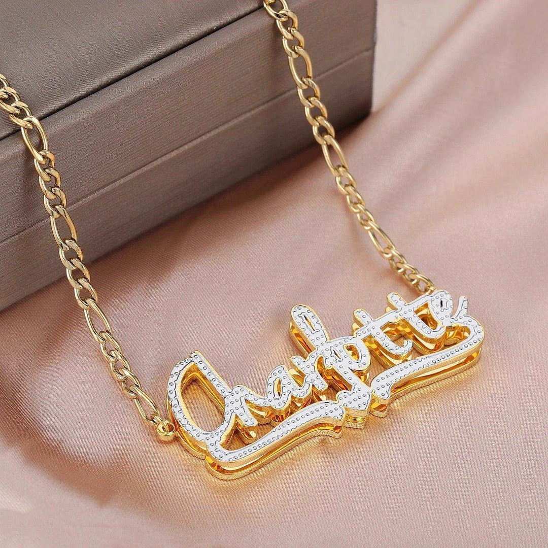 a gold plated necklace with a nameplate on it