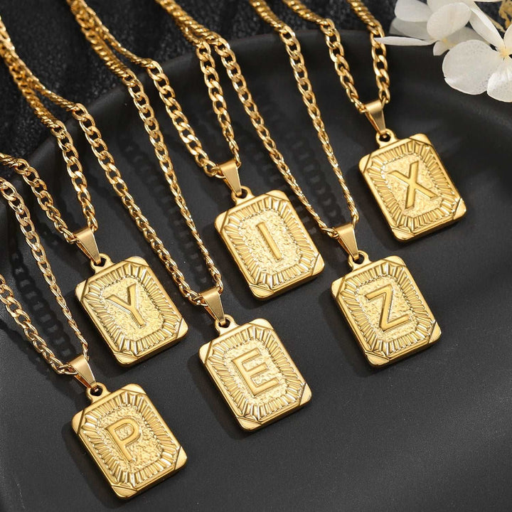 a group of gold necklaces sitting on top of a black plate