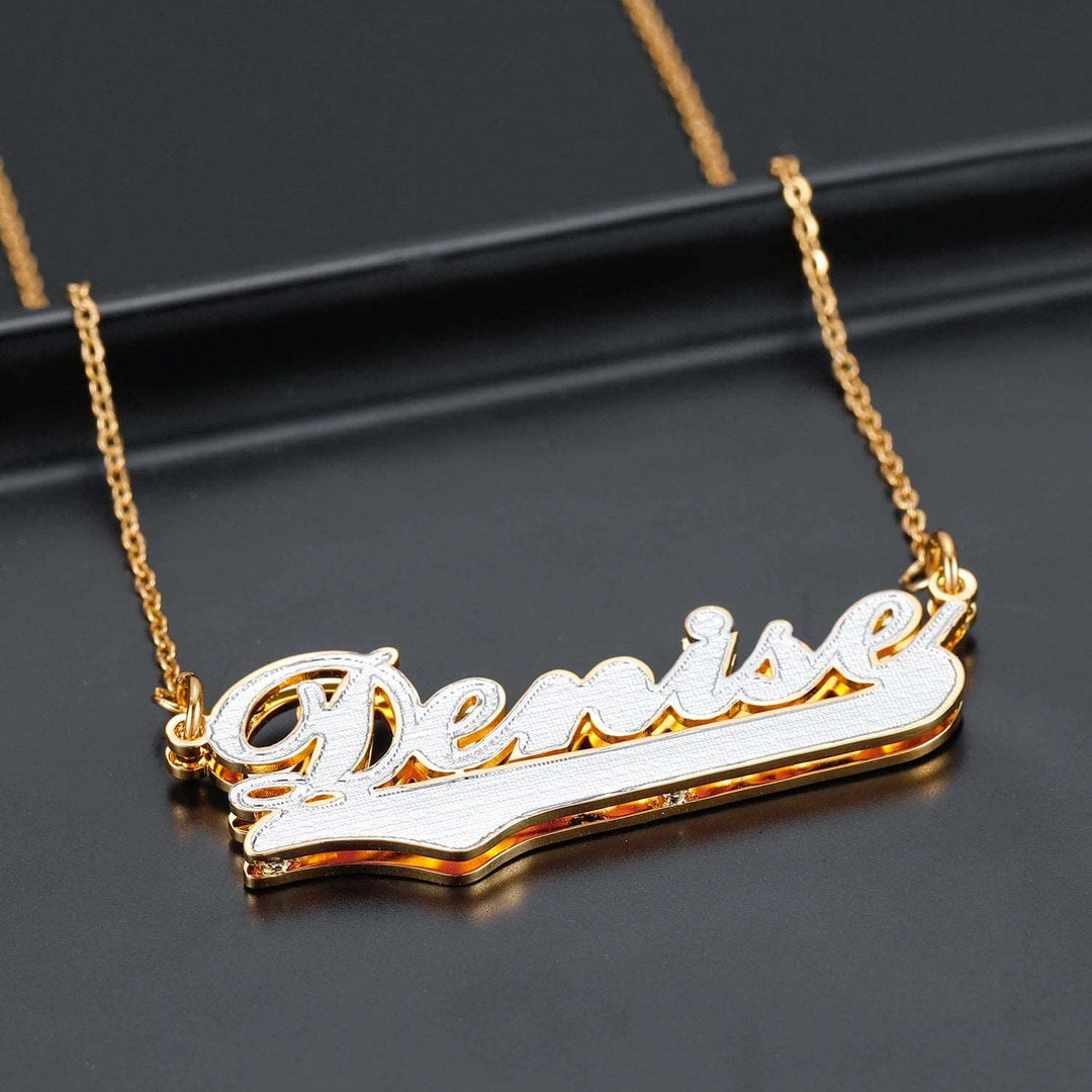 a gold necklace with the word grease on it