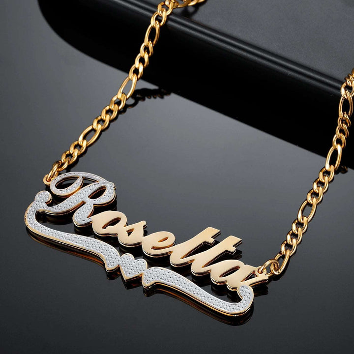 a close up of a gold necklace with a name on it