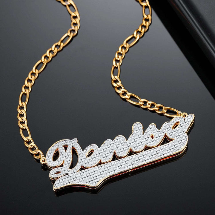 a gold chain with a diamond nameplate on it