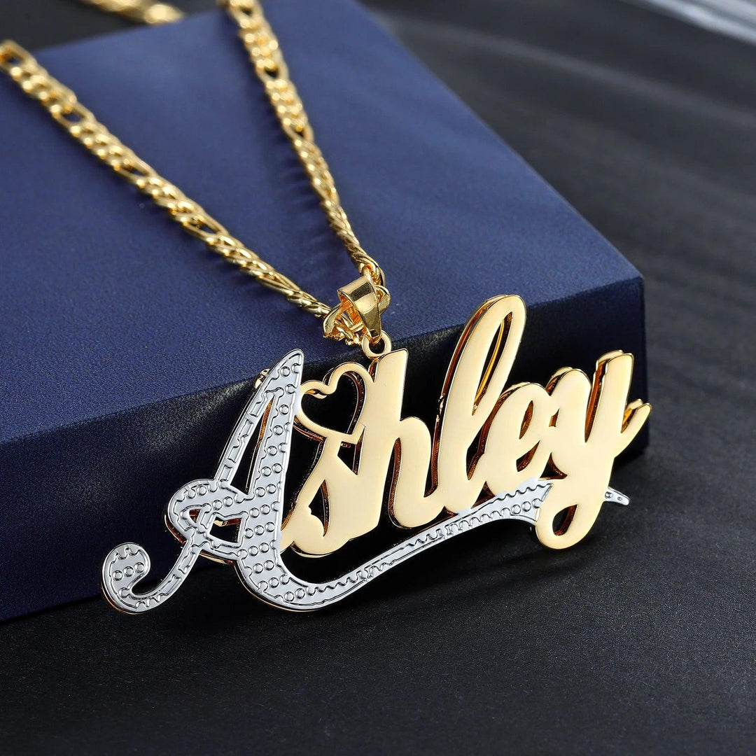 a necklace with a name on it sitting on a blue box