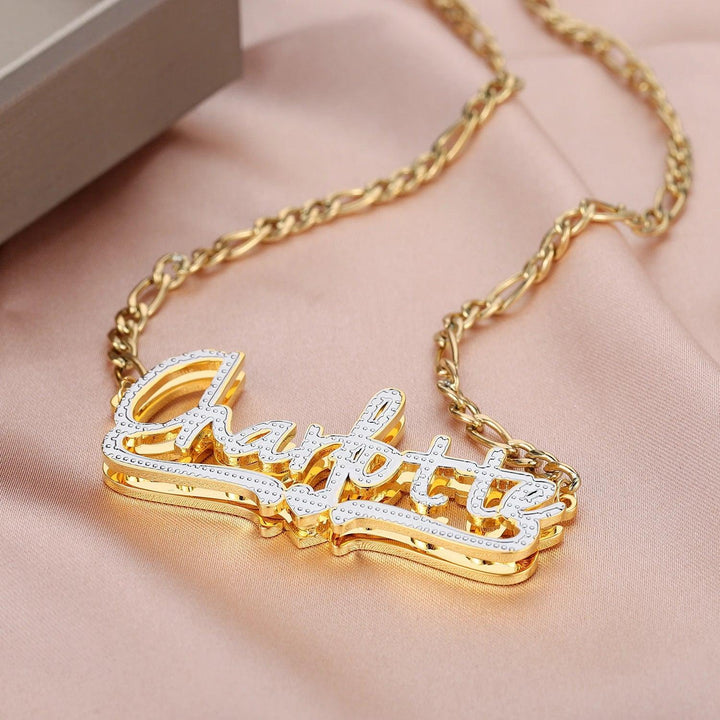 a gold necklace with a nameplate on it