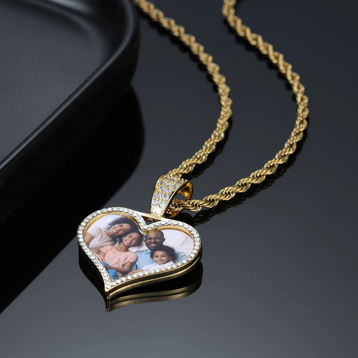 a heart shaped necklace with a picture of a couple on it