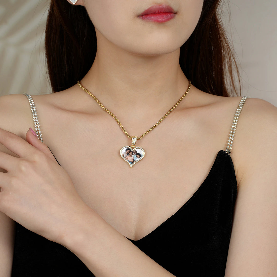 a woman in a black dress wearing a heart shaped necklace