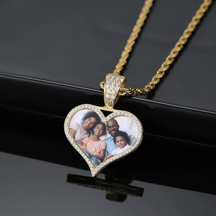 a heart shaped pendant with a family picture on it