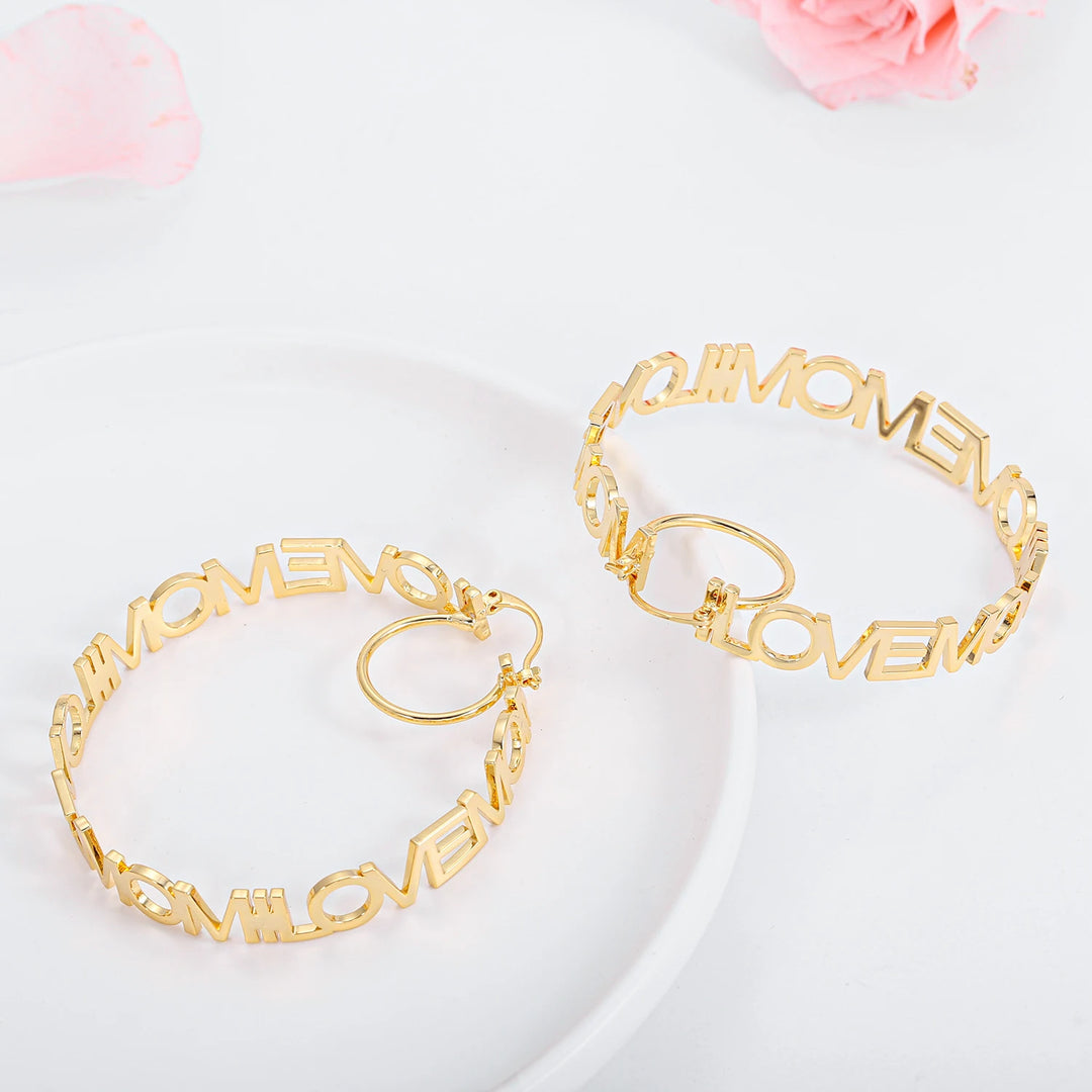 a couple of gold bracelets sitting on top of a white plate