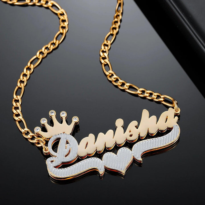 a gold necklace with a crown and name on it