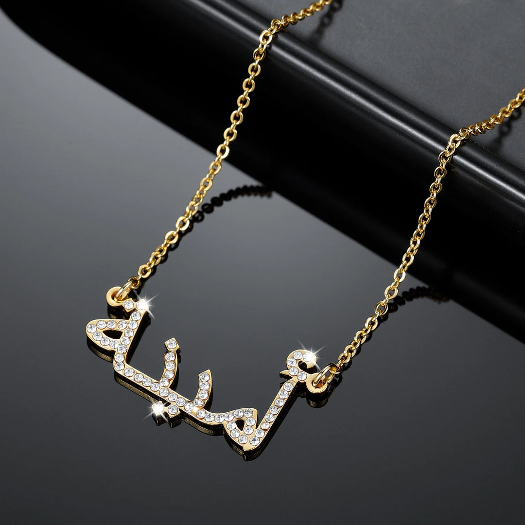 a gold necklace with the word love written in arabic